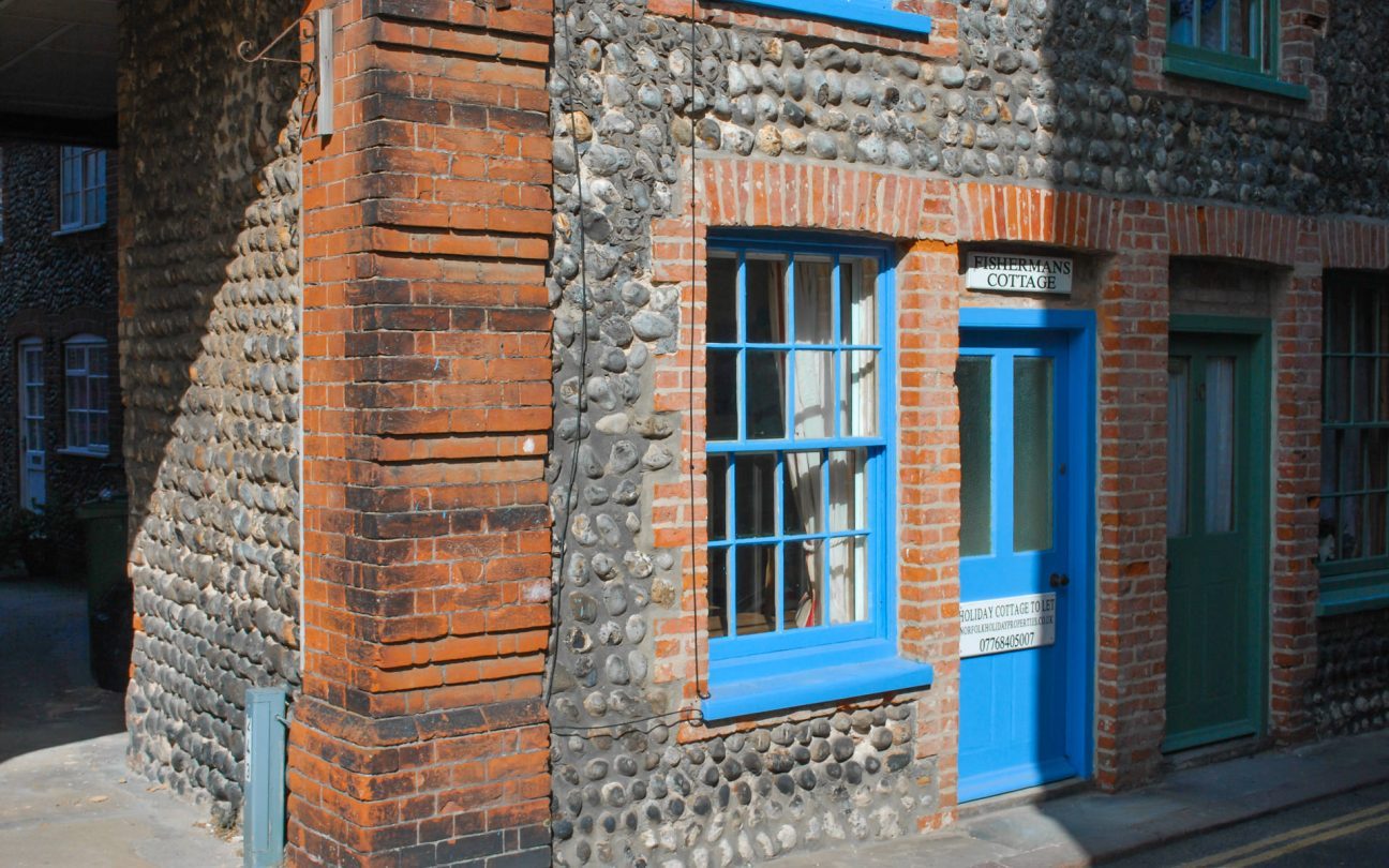 Outside shot of Fisherman's Cottage, showing the blue framed windows and door. 