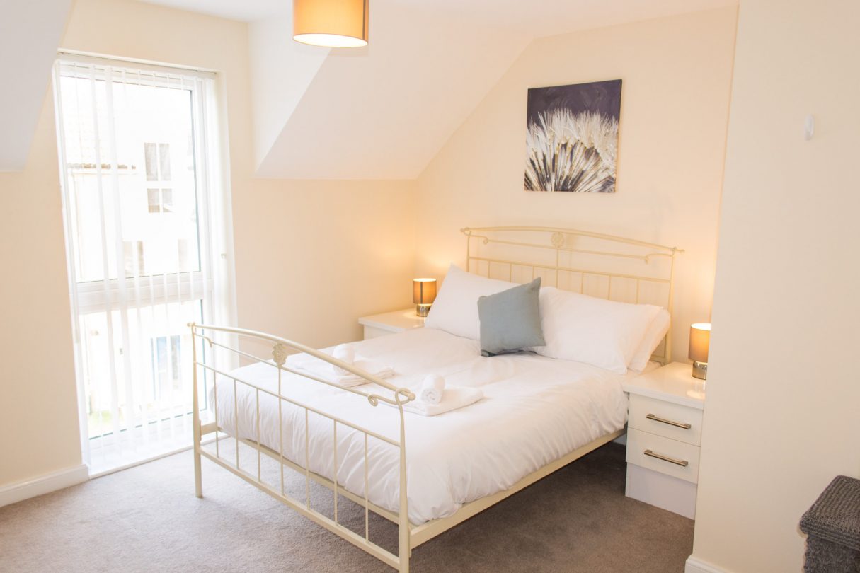 Double bedroom with large windows in family home Peacock House