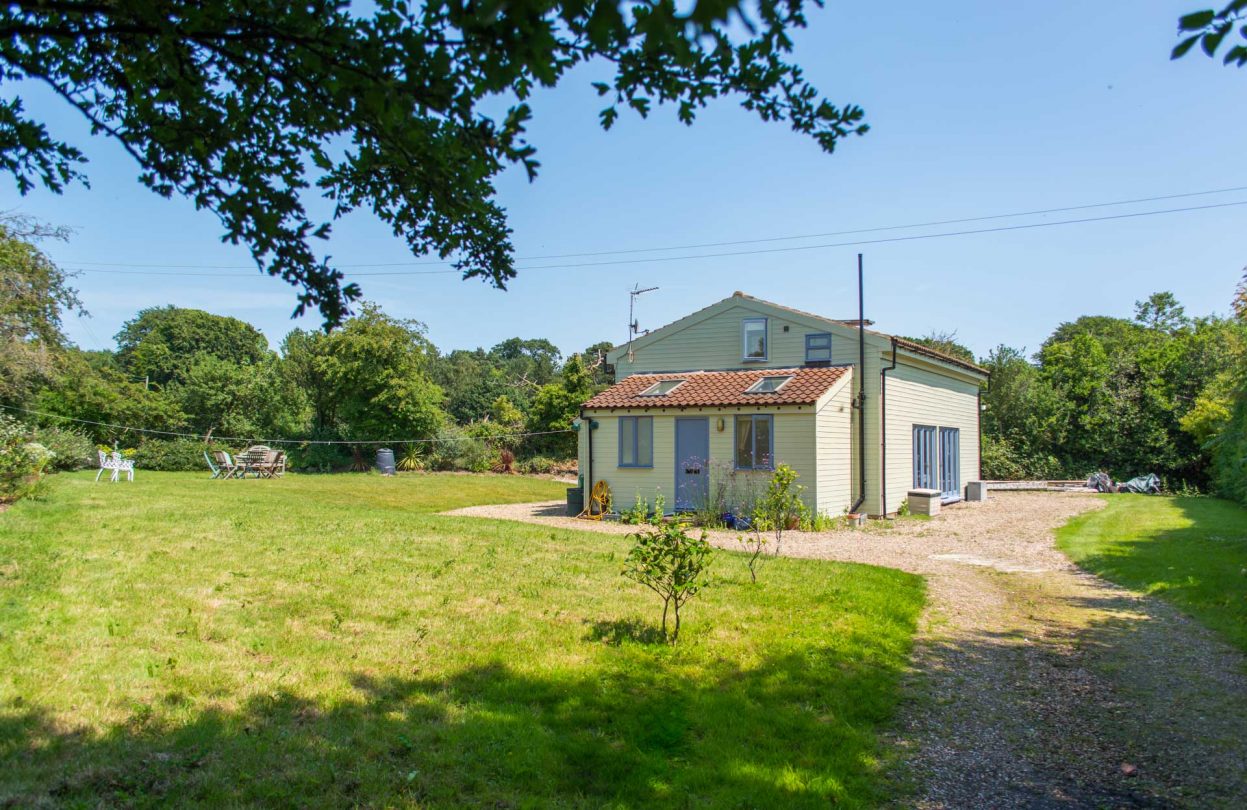 Outside view of Hen Barn showing the garden on a sunny day.