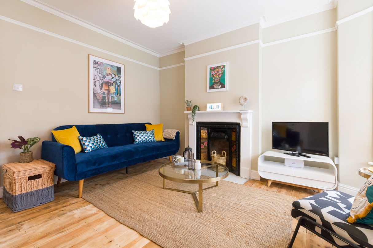 Living room with blue sofa and yellow pillows. 