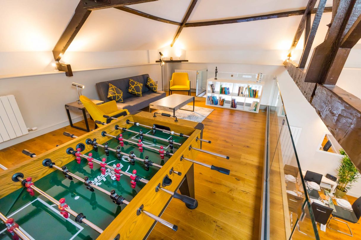 Upper mezzanine level with football table and living space.