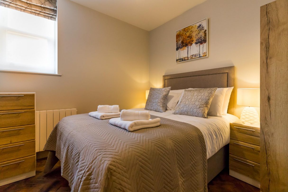 Double bedroom with bedside lamps and towels.