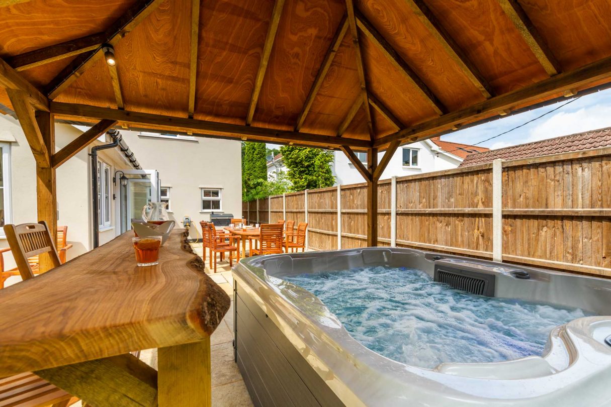 Norwich property, Woodside House, showing hot tub and wooden bar with shelter at the rear of the property. 