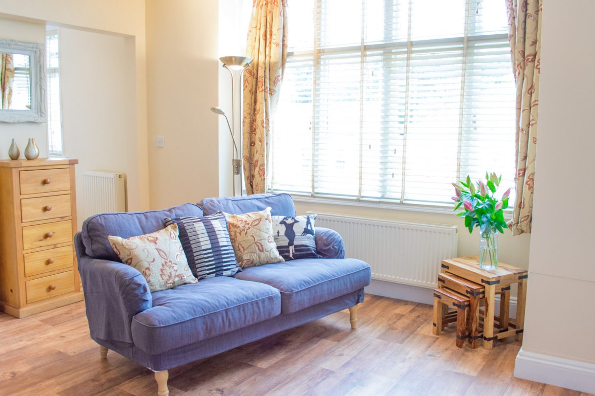 Apartment 3 | York Terrace living room showing blue sofa and additional furnishings. 