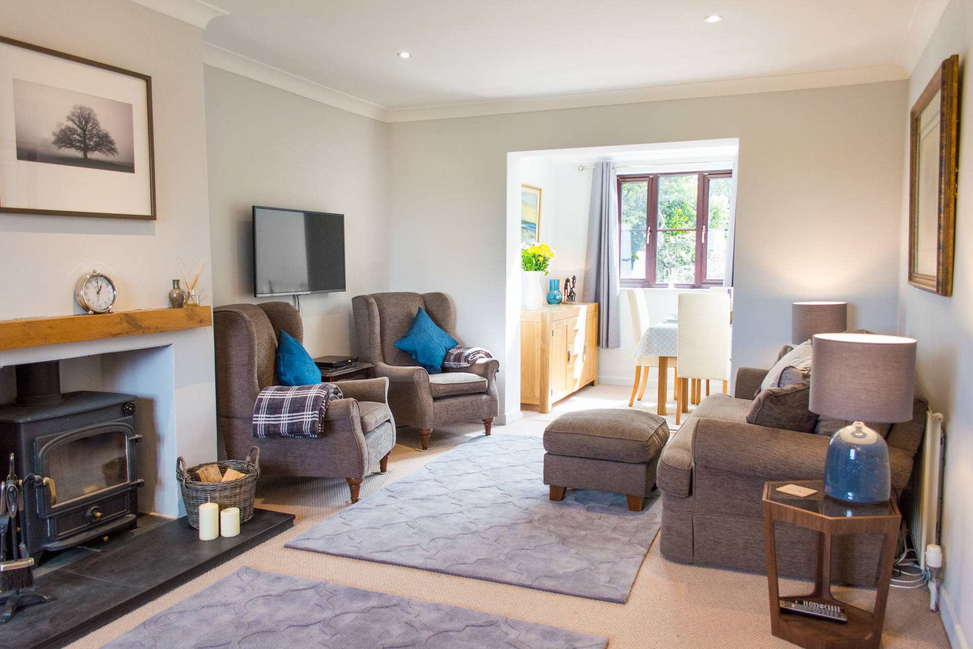 Spacious living room, with comfortable seating and large rugs on the floor.