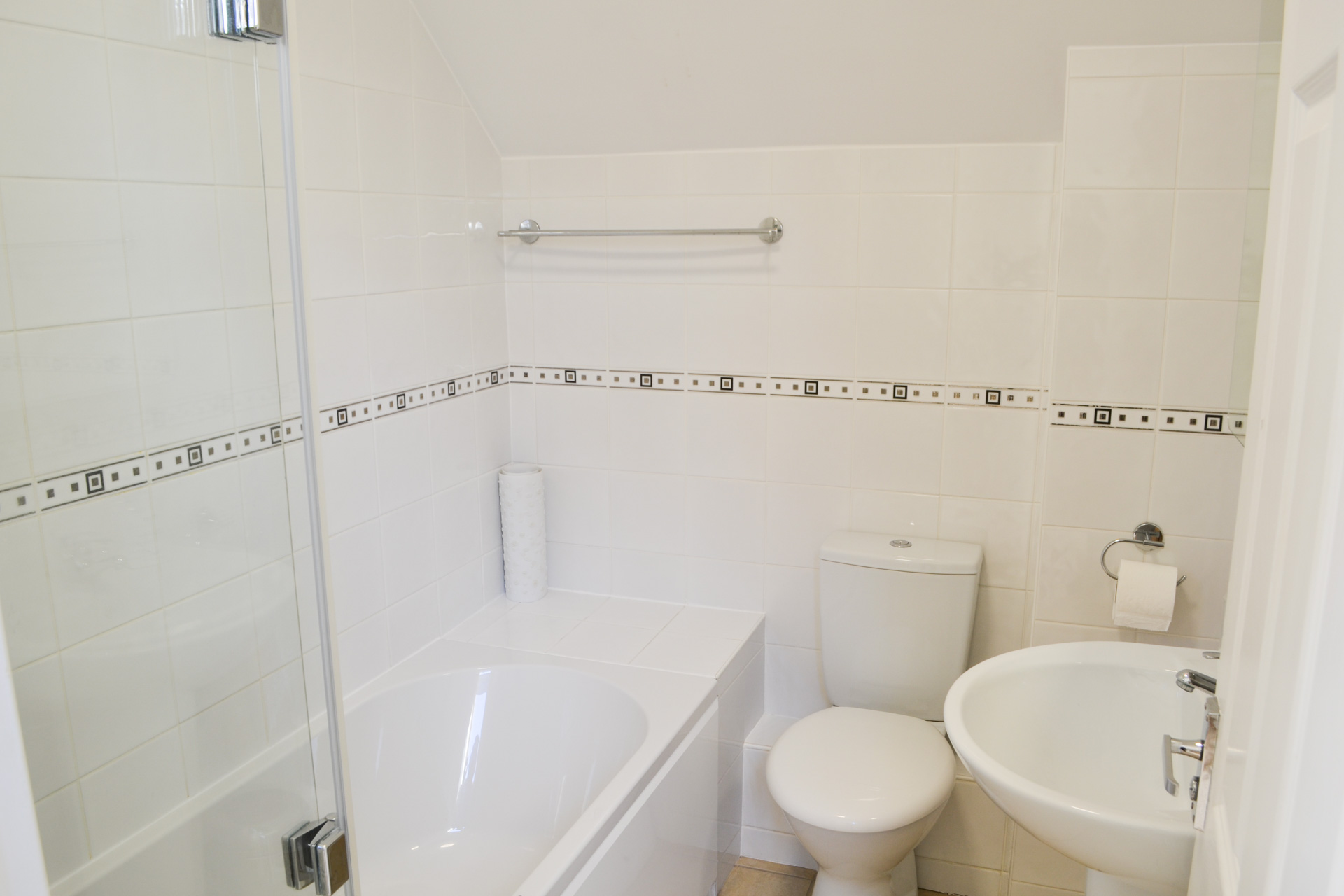 Bathroom with shower over bath and toilet.