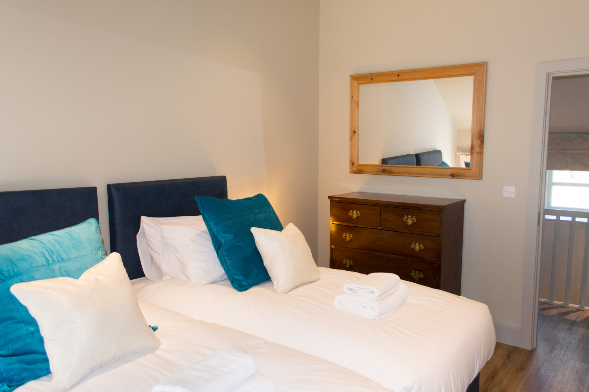 Twin bedroom with mirror in the background.