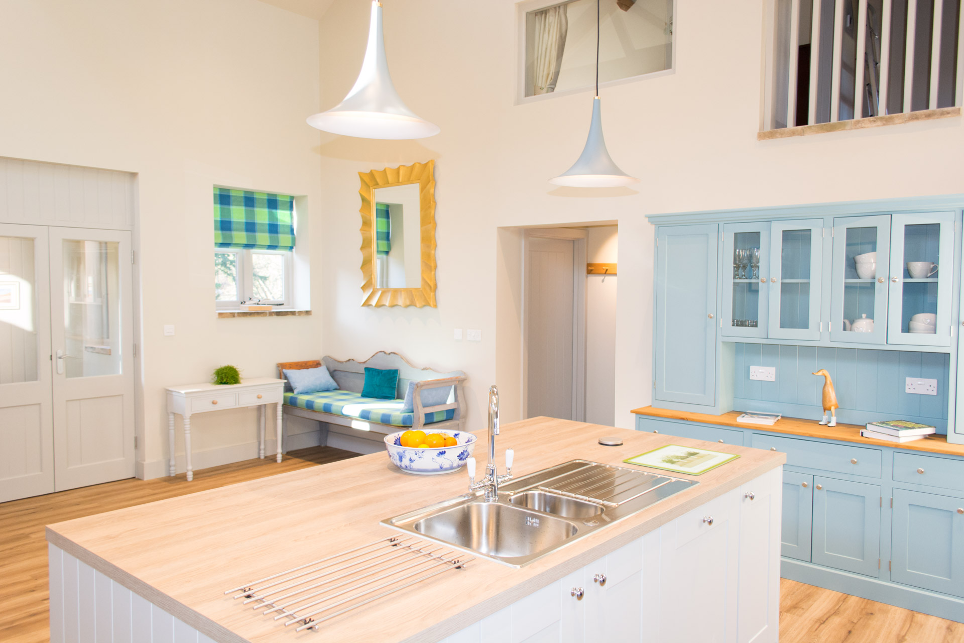 Renovated kitchen showing the kitchen island and sink angled towards the entrance to Boathouse Barn.