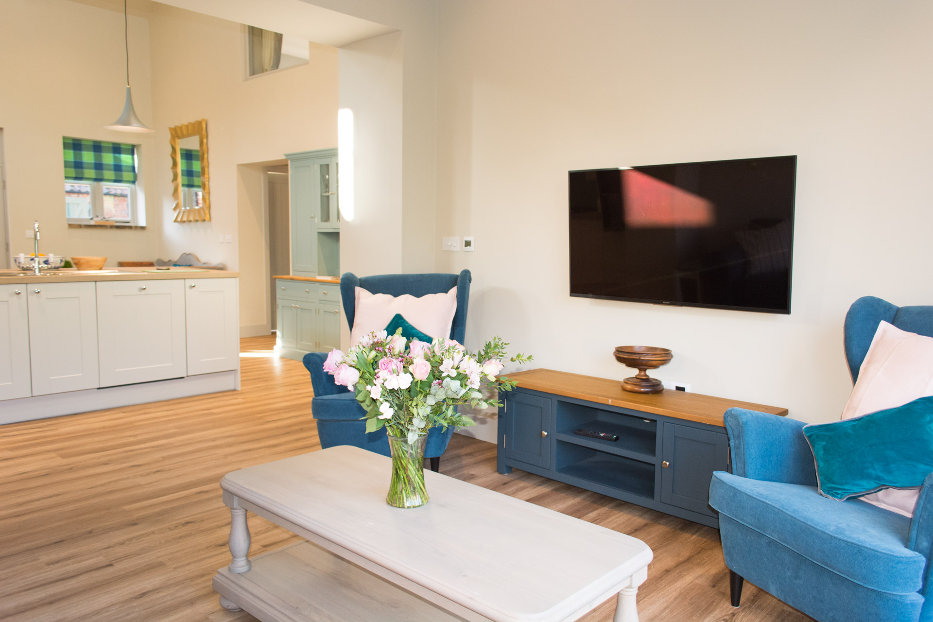 Interior holiday cottage living area showing a TV and blue armchairs.