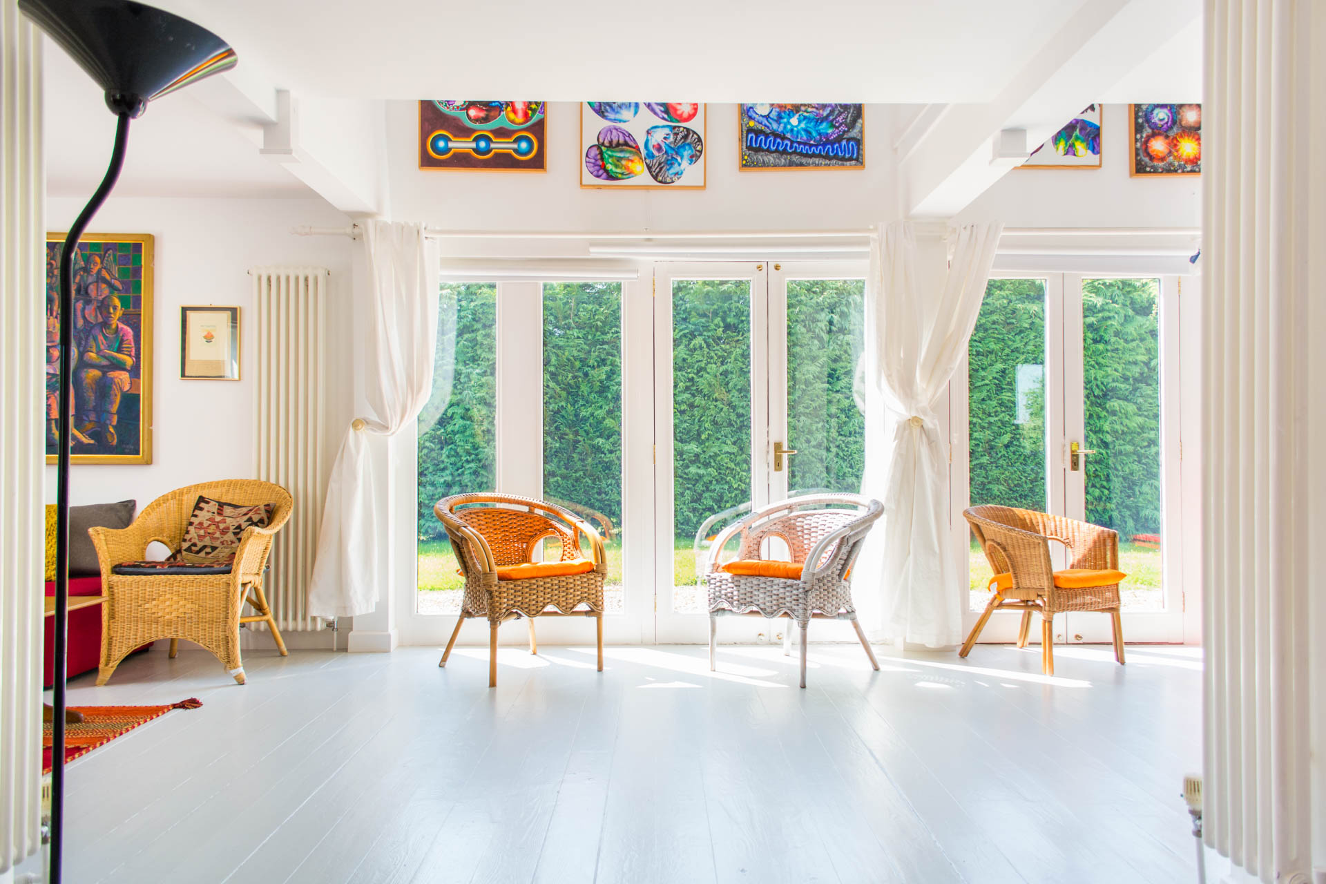 Low level shot taken from the ground of several chairs placed in front of glass doors which look out onto the garden.