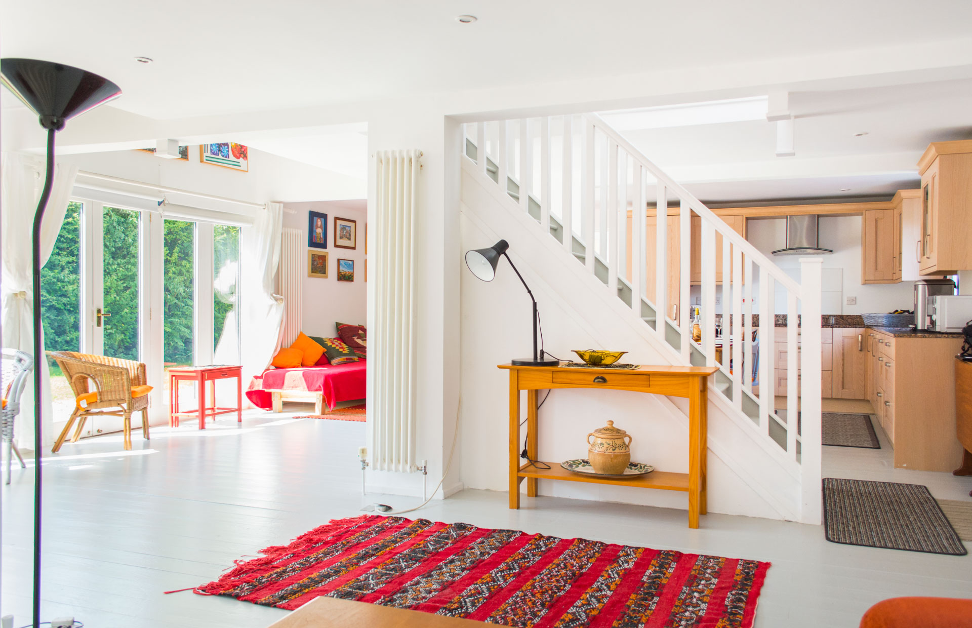 Staircase leading up the first floor, showing a large red rug laid at the side of the staircase.