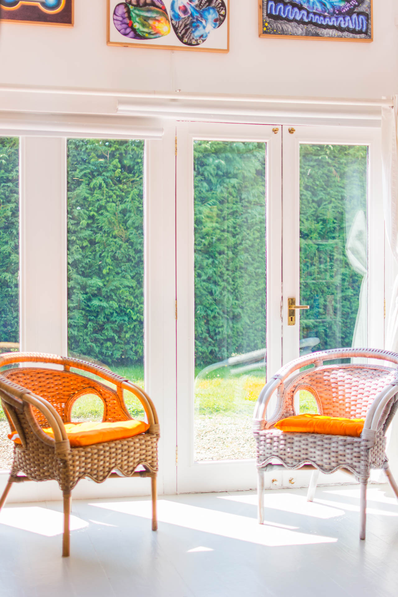 Photo of two chairs in front of glass doors leading out to the garden.