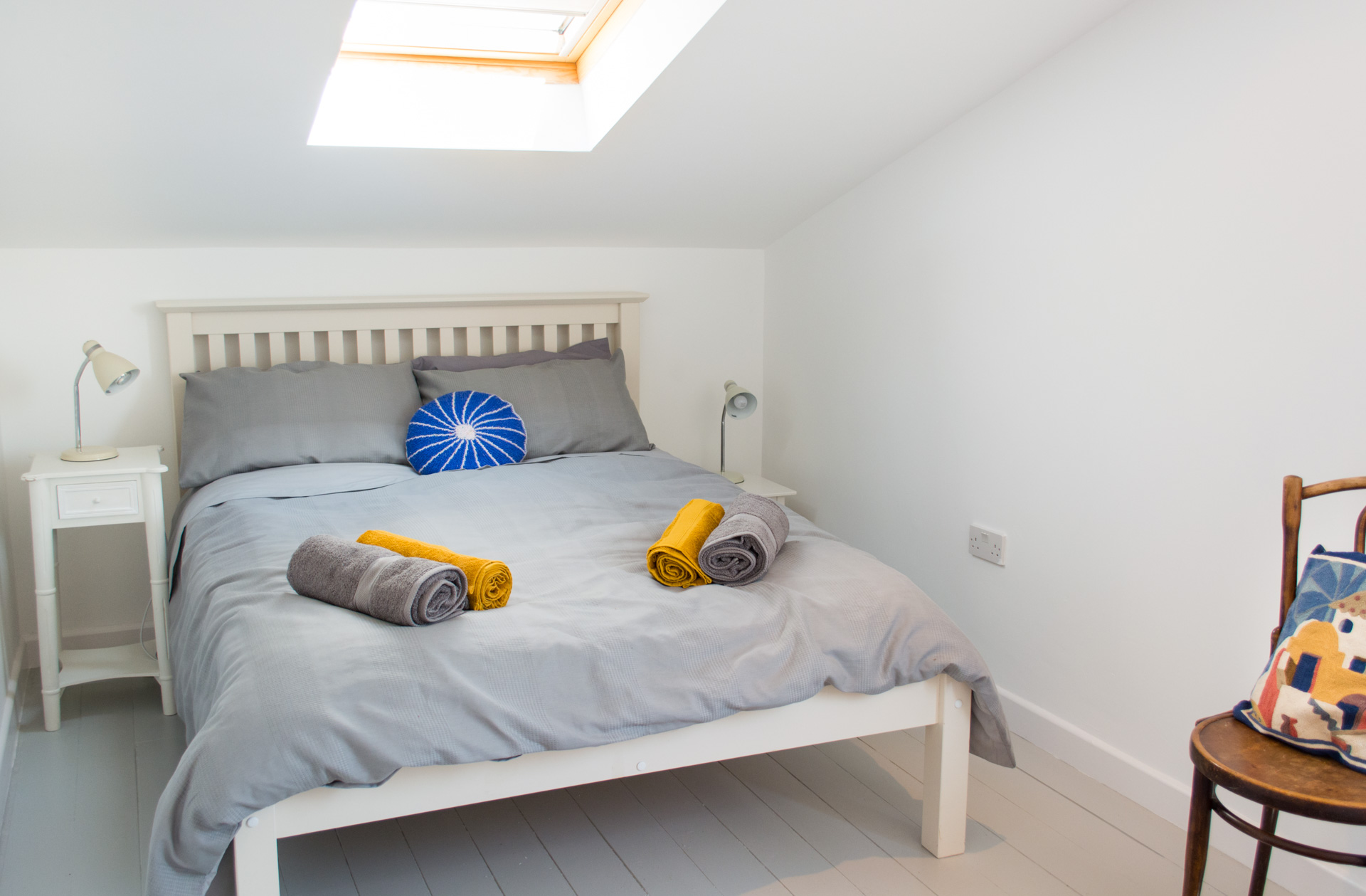 Hen Barn double bedroom with orange and grey towels on the bed.