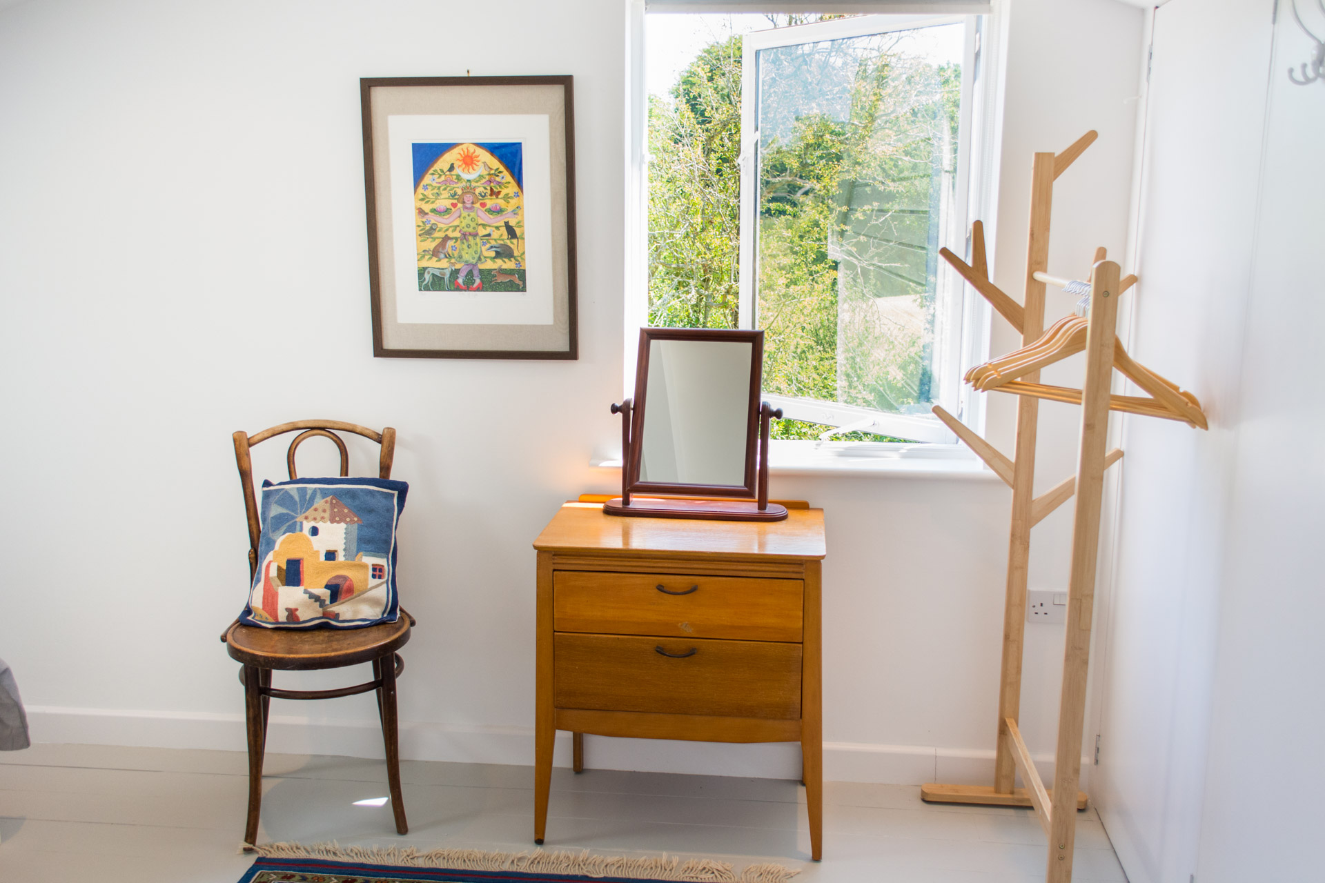 Dressing table photo with large open window in the background.