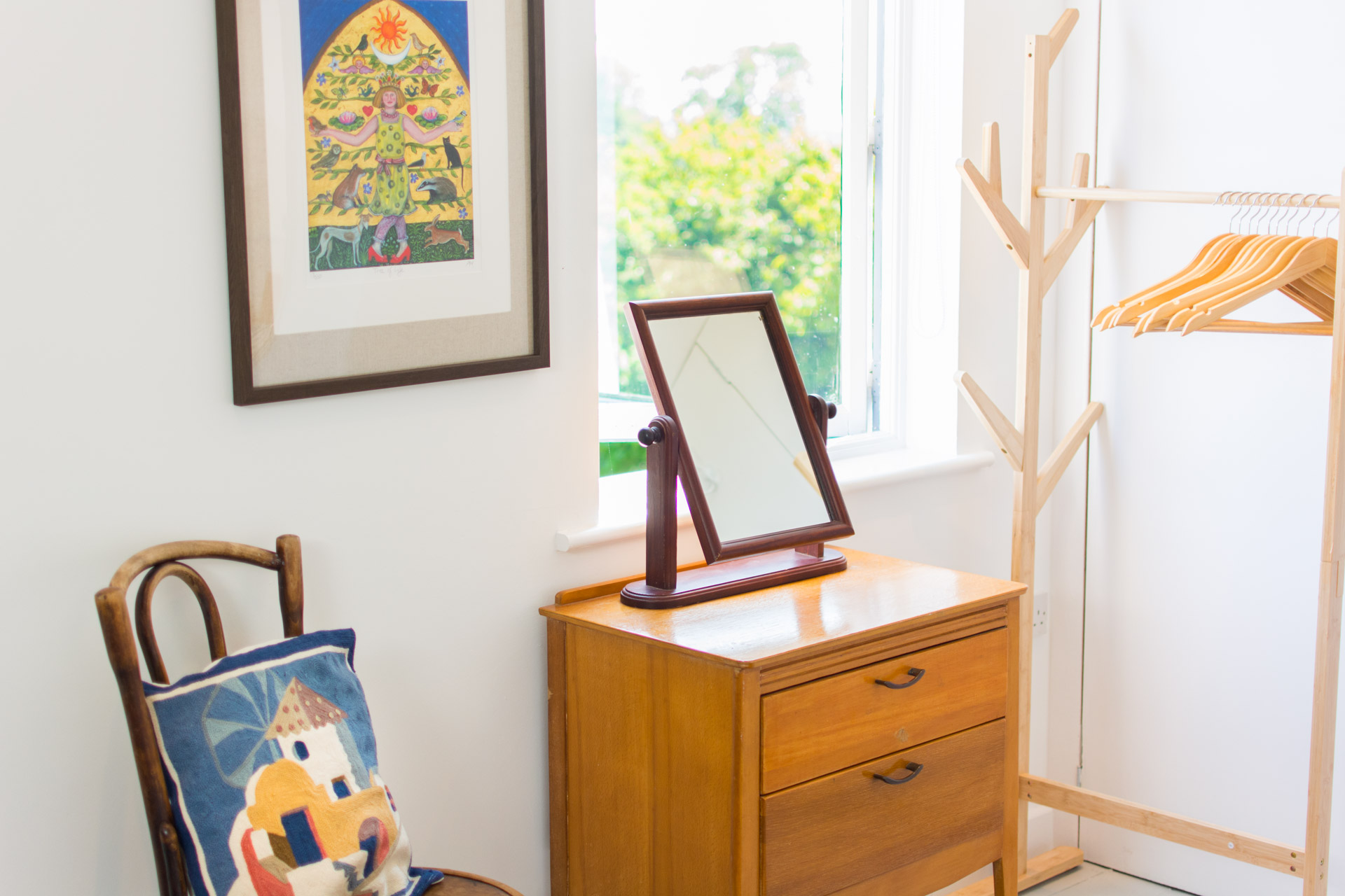 Dressing table with mirror in front of a window in the main bedroom.